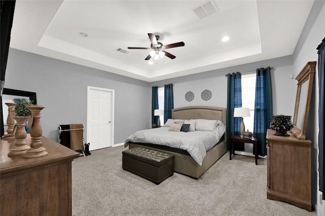 bedroom featuring a tray ceiling and visible vents