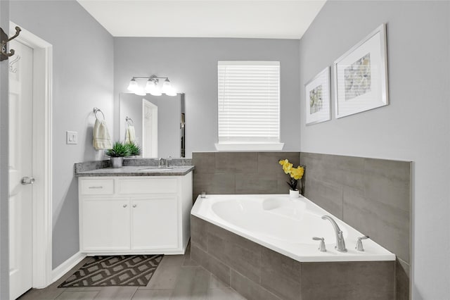 bathroom with tile patterned flooring, a garden tub, and vanity