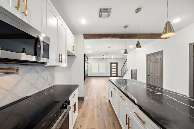 kitchen featuring beam ceiling, stainless steel appliances, visible vents, decorative backsplash, and white cabinetry