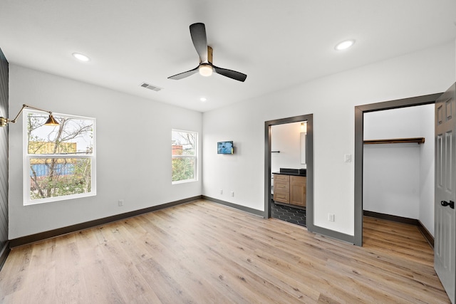 unfurnished bedroom with visible vents, light wood-style flooring, and baseboards