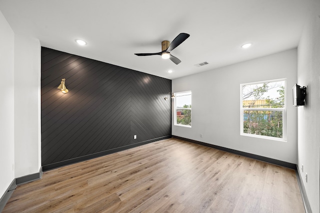 spare room with recessed lighting, visible vents, an accent wall, wood finished floors, and baseboards