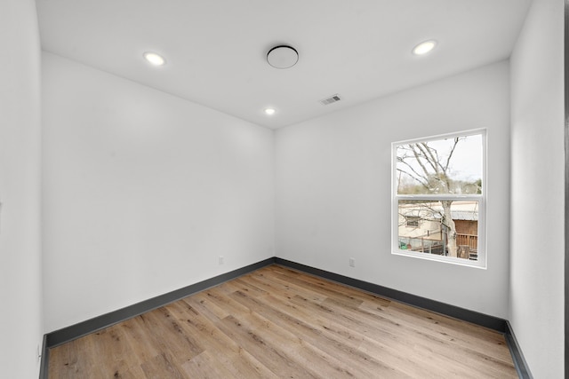 empty room featuring light wood finished floors, recessed lighting, visible vents, and baseboards