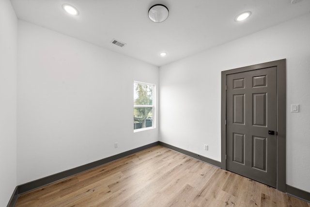 unfurnished room with light wood-style floors, recessed lighting, visible vents, and baseboards