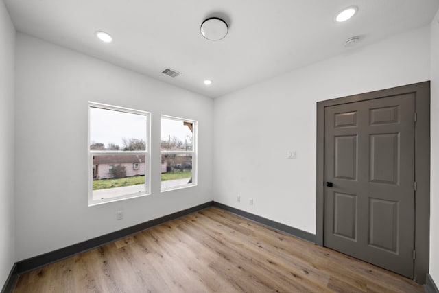 spare room featuring recessed lighting, light wood-type flooring, visible vents, and baseboards