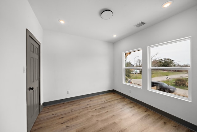 spare room with light wood-style floors, visible vents, baseboards, and recessed lighting