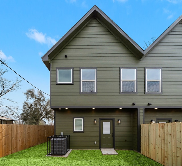 back of house with fence and a yard