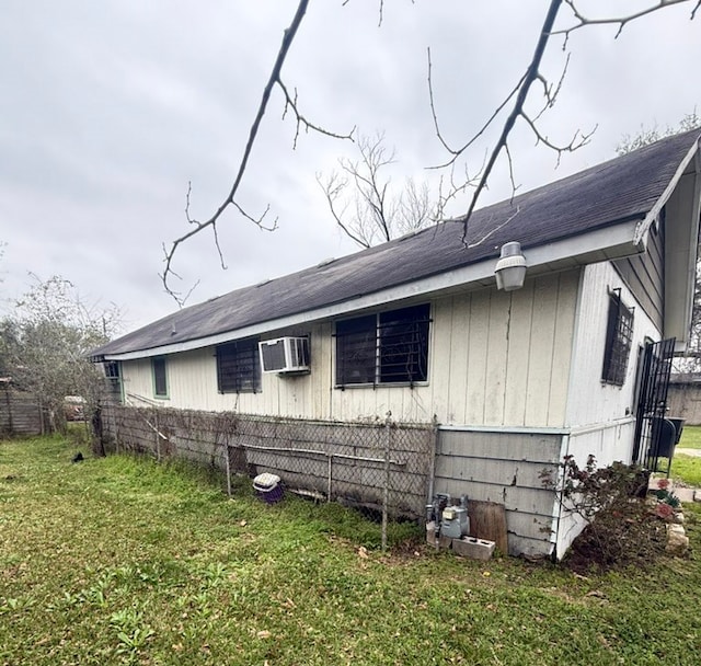 view of property exterior featuring a wall mounted air conditioner and a yard