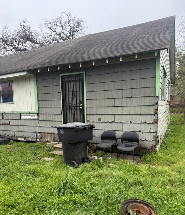 rear view of property with a shingled roof