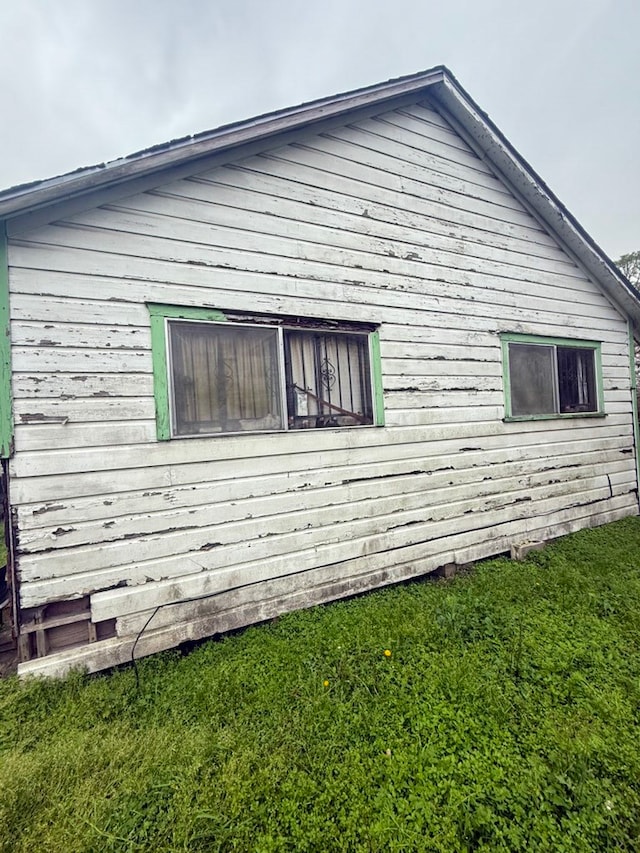 view of side of home with a yard