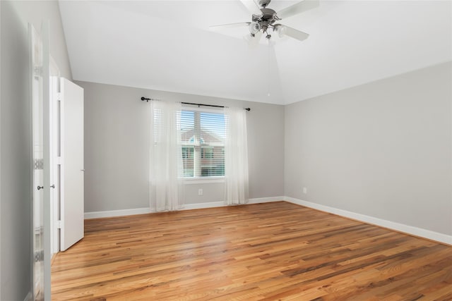 empty room with light wood finished floors, baseboards, vaulted ceiling, and a ceiling fan