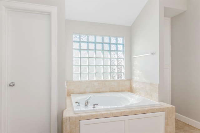 full bathroom featuring lofted ceiling, tile patterned flooring, and a bath