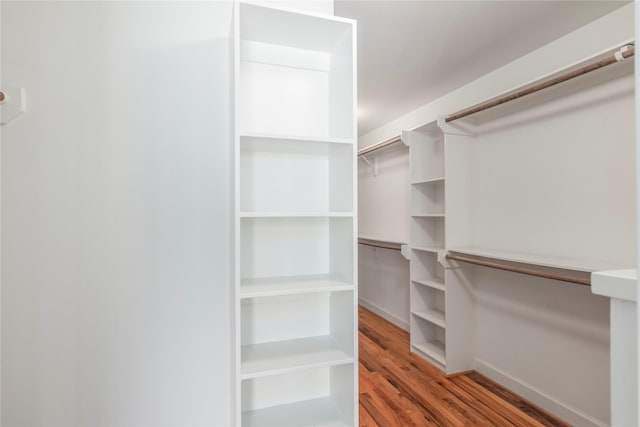 walk in closet with wood finished floors