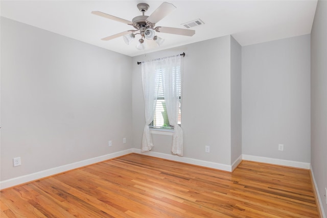 empty room with baseboards, a ceiling fan, visible vents, and light wood-style floors