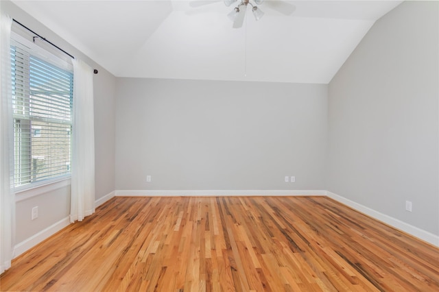 spare room with lofted ceiling, ceiling fan, light wood-style flooring, and baseboards