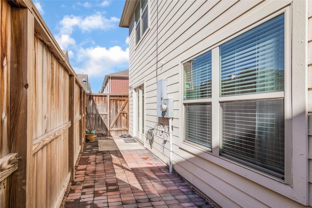 view of home's exterior with a gate, a patio area, and fence