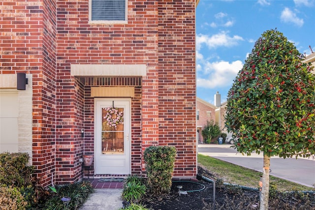 property entrance featuring brick siding