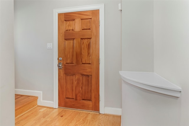 entryway featuring baseboards and wood finished floors