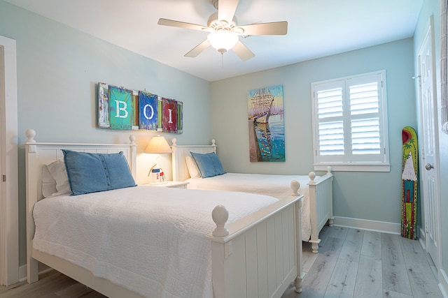 bedroom featuring ceiling fan, baseboards, and wood finished floors