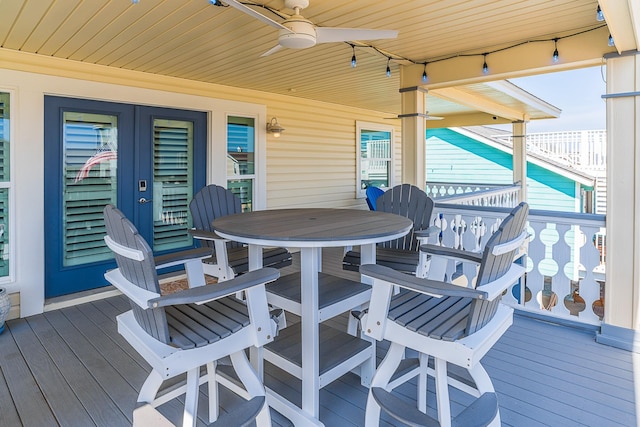 wooden deck with outdoor dining space and ceiling fan