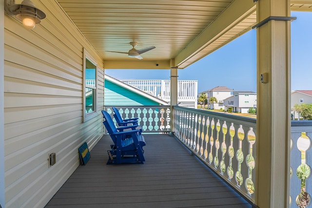 deck with a residential view and a ceiling fan