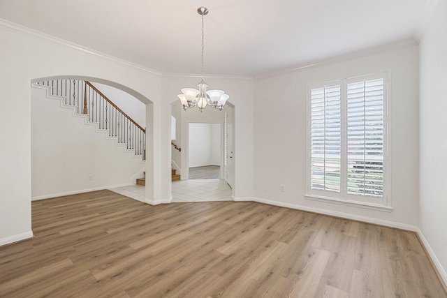 interior space featuring arched walkways, baseboards, light wood-style flooring, stairway, and ornamental molding