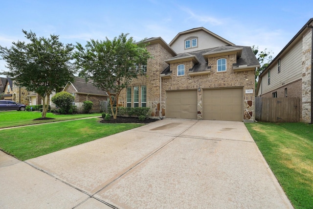 view of front of home featuring concrete driveway, an attached garage, fence, a front yard, and brick siding