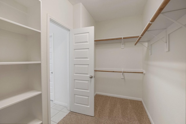 walk in closet featuring light carpet and light tile patterned floors