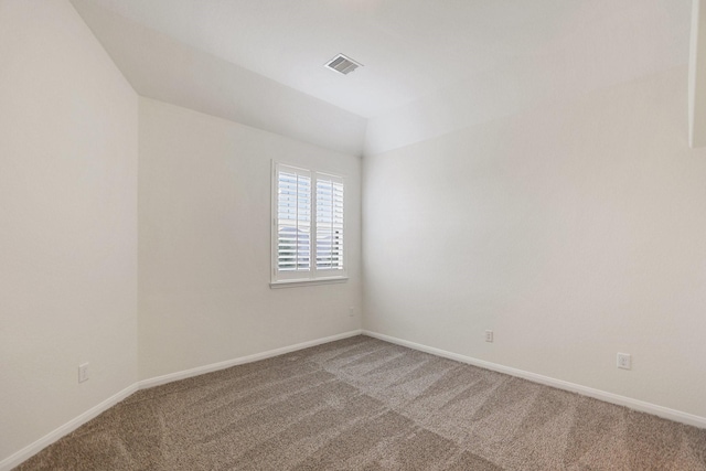 spare room featuring carpet, visible vents, and baseboards