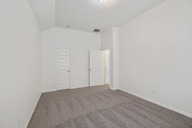 unfurnished bedroom featuring carpet flooring, vaulted ceiling, visible vents, and baseboards