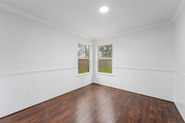 spare room with a wainscoted wall, hardwood / wood-style floors, a textured ceiling, and crown molding