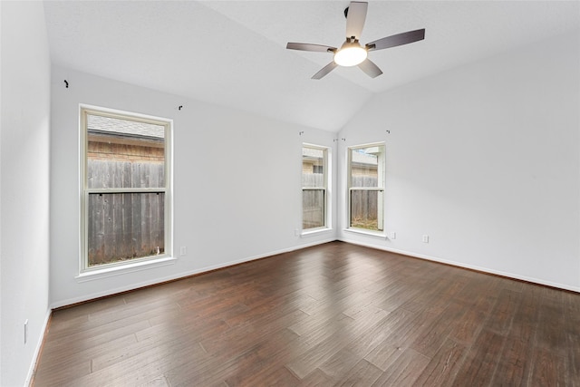 spare room with lofted ceiling, dark wood finished floors, and baseboards