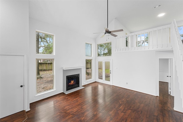 unfurnished living room with plenty of natural light, high vaulted ceiling, and wood finished floors