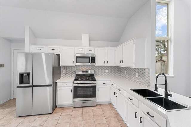 kitchen featuring light countertops, appliances with stainless steel finishes, a sink, and a healthy amount of sunlight