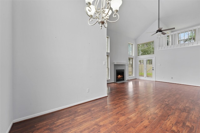 unfurnished living room with plenty of natural light, a fireplace with flush hearth, high vaulted ceiling, and wood finished floors