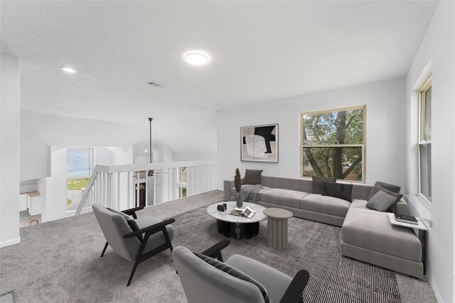 carpeted living area with a textured ceiling, visible vents, and recessed lighting