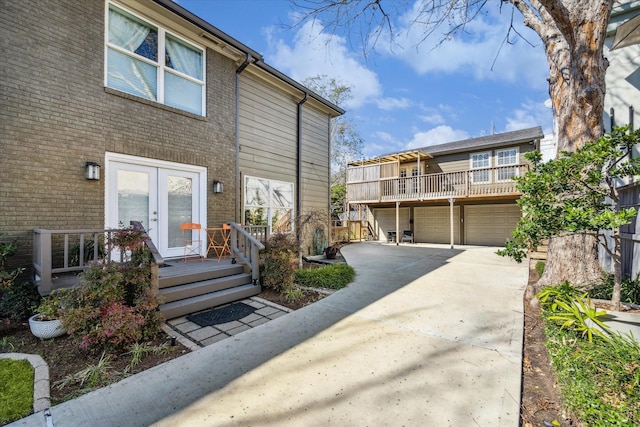 townhome / multi-family property featuring french doors, concrete driveway, and brick siding