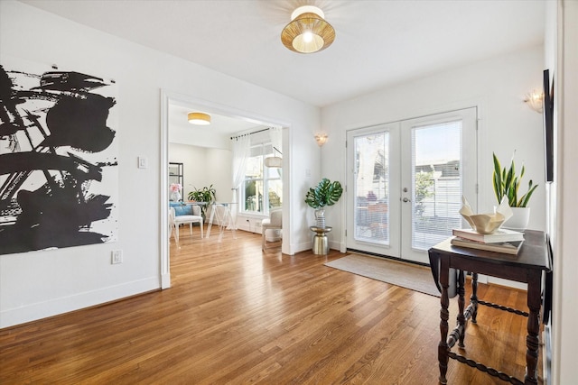 doorway featuring french doors, wood finished floors, and baseboards