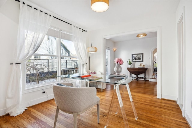 dining area featuring wood finished floors, a wealth of natural light, and baseboards