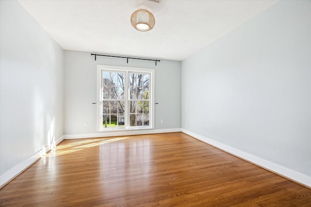 empty room featuring wood finished floors and baseboards