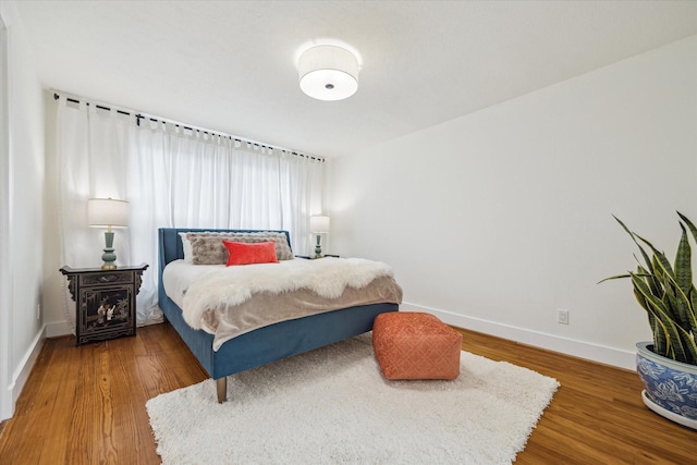 bedroom with baseboards and wood finished floors