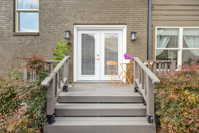 view of exterior entry with brick siding and french doors