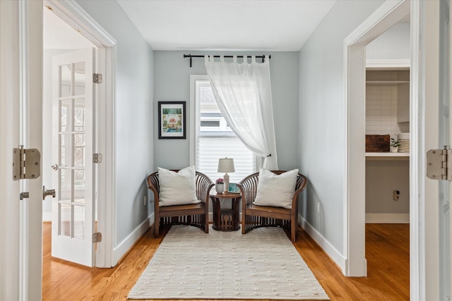 living area featuring light wood finished floors and baseboards