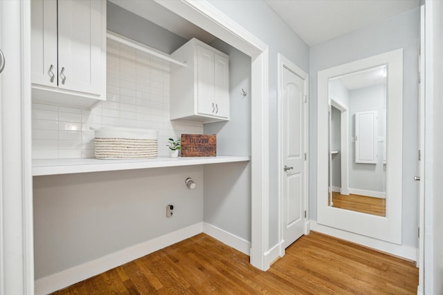 laundry area with baseboards and wood finished floors