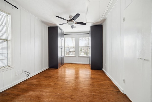 unfurnished bedroom featuring wood finished floors, a ceiling fan, and crown molding