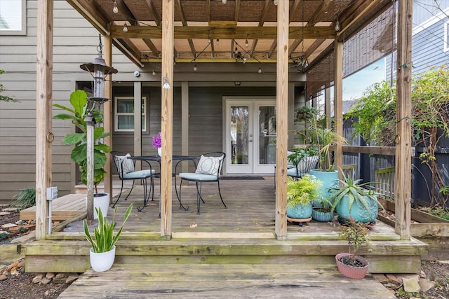 deck with french doors and outdoor dining area