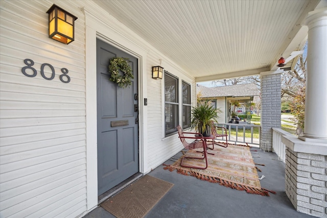 view of exterior entry featuring covered porch