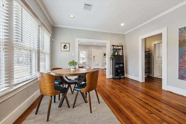 dining area featuring baseboards, visible vents, dark wood-style floors, ornamental molding, and recessed lighting