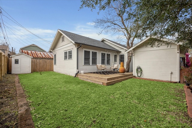 back of house featuring a storage shed, fence, a deck, a yard, and an outdoor structure