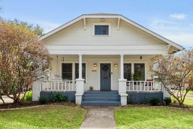 bungalow-style house with a porch and a front lawn