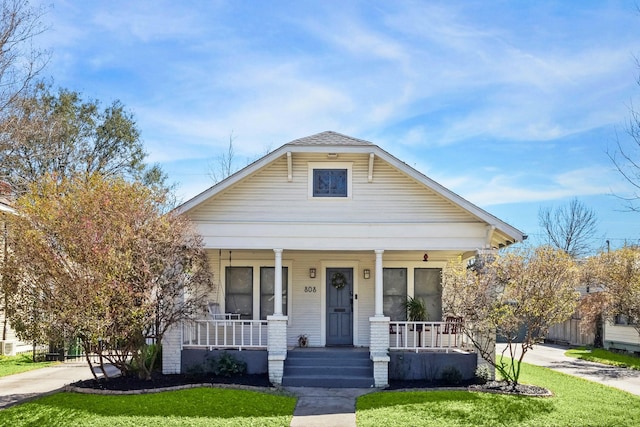 bungalow-style house with a porch and a front lawn